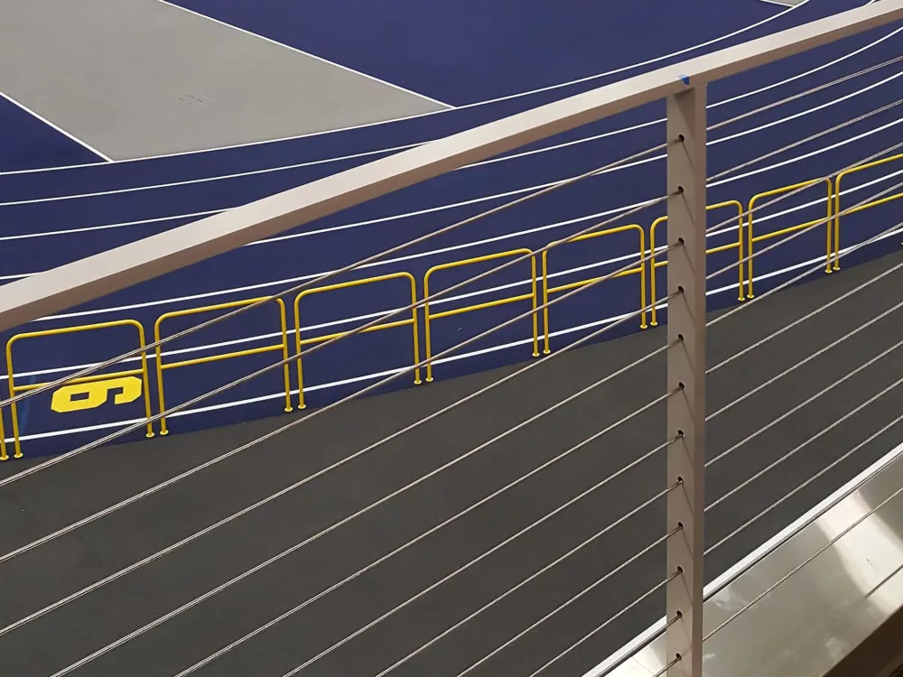 A close-up view of the stadium railing, as well as the aluminum rail enclosing the track.